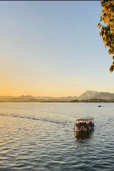 Boat ride during sunset with calm waters and mountains in the background