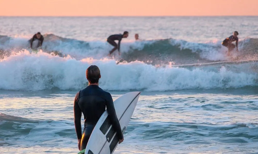 Surfer watching waves at sunset near Borrbo Gokarna