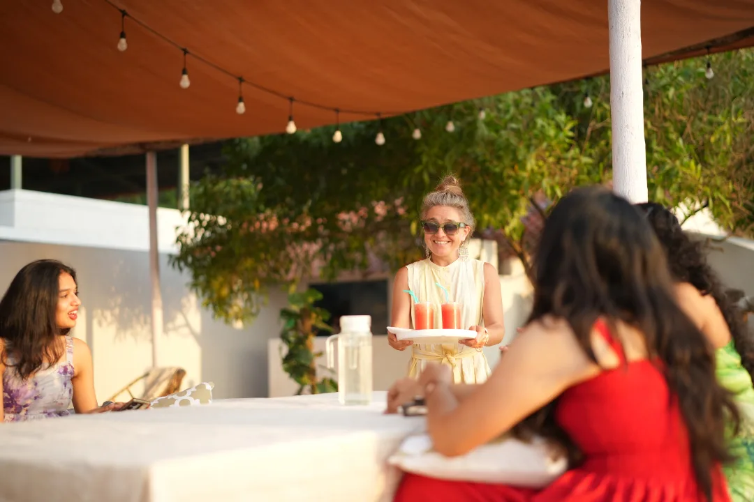 Friends laughing and enjoying drinks at a beachside café